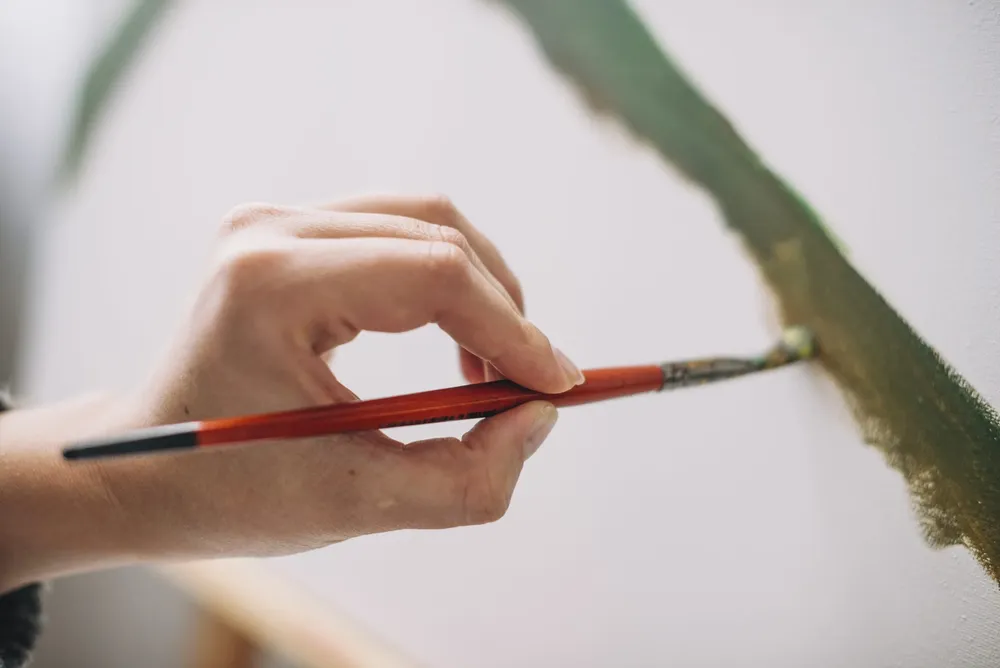 mano-pintando-un-cuadro-scaled