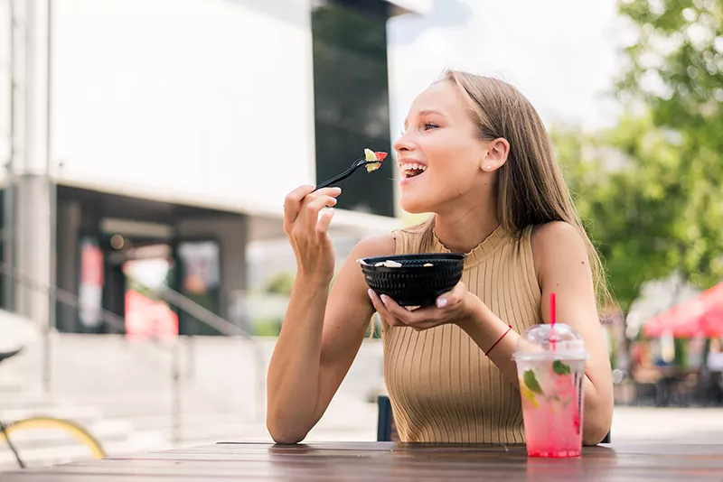 close-up-of-young-attractive-woman-salad-at-street